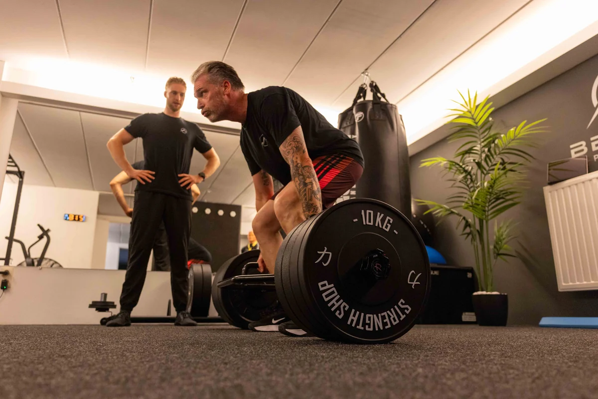 Robbe Berger begeleidt een klant tijdens krachttraining