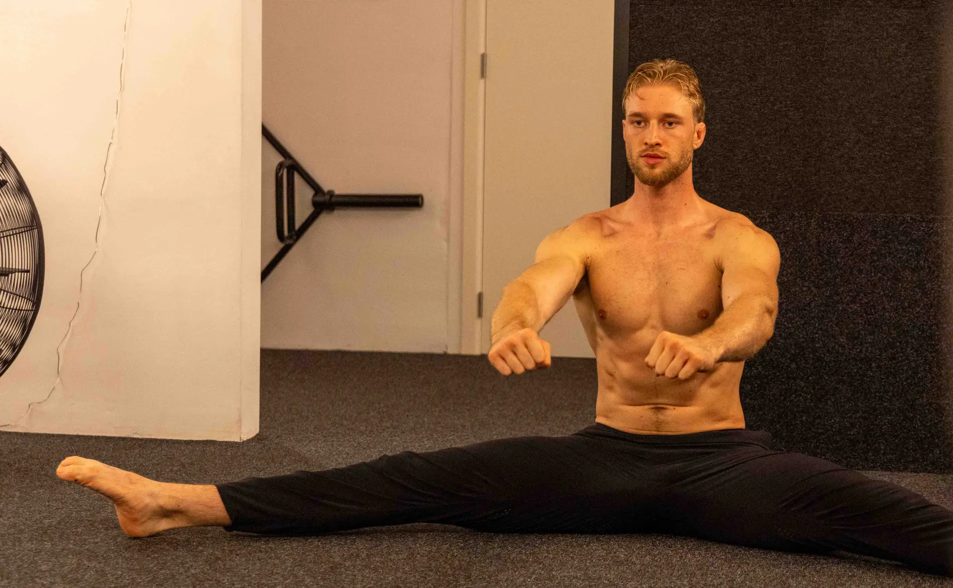 Robbe Berger doet een volledige split in de studio, bewijs van hersteld bewegingsbereik